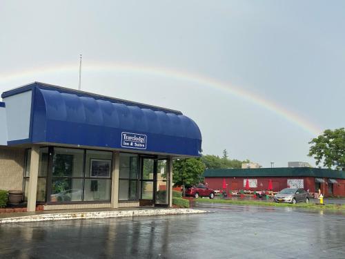 a store with a blue roof in a parking lot at Travelodge Inn & Suites by Wyndham Albany in Albany
