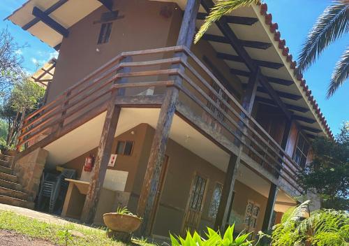 a house with a wooden staircase on the side of it at Finca La Vispera in Samaipata