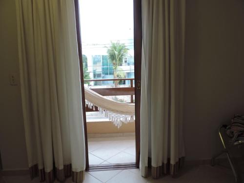 an open door with a view of a balcony at Hotel Costa Balena-Piscina Aquecida Coberta in Guarujá