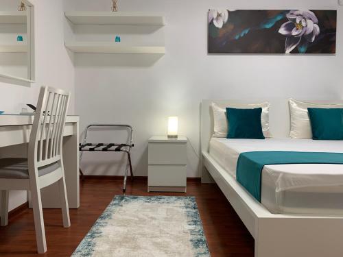 een slaapkamer met een bed, een bureau en een stoel bij Ana Center Apartment in Galaţi