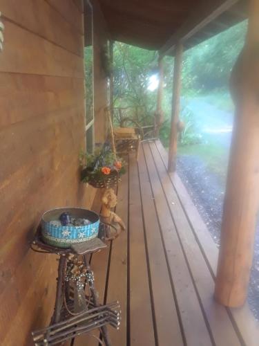 a porch of a house with a bowl on a stand at Alaska's Northland Inn in Trapper Creek