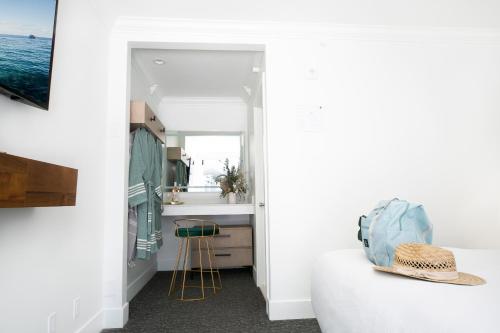 een kamer met witte muren en een keuken met een tafel bij Bellanca Hotel in Avalon