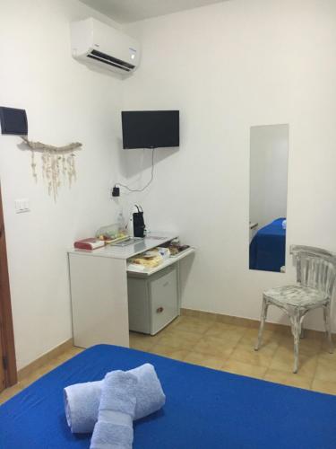 a room with a bed and a desk and a tv at Camera Torre Dell'Orso in Torre dell'Orso