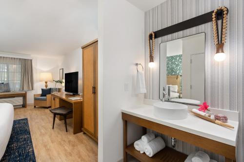 a hotel room with a bathroom with a sink and a mirror at Mason Beach Inn in Santa Barbara