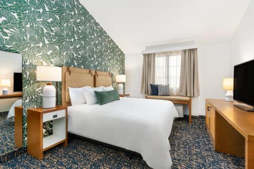 a hotel room with a bed and a tv at Mason Beach Inn in Santa Barbara