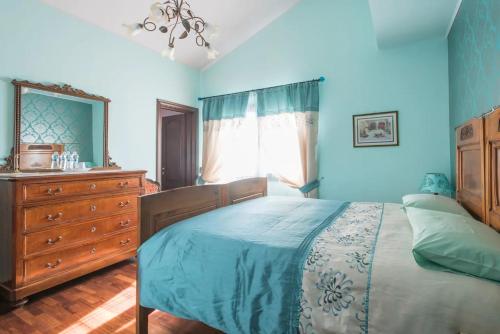 Locanda San Marino Al Coppo في Monte Grimano Terme: غرفة نوم زرقاء مع سرير وخزانة