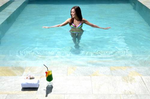 a woman is standing in a swimming pool at Lex Hotel Cebu in Cebu City