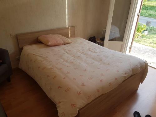 1 dormitorio con 1 cama con edredón blanco y ventana en Maison Andinette, en Blis-et-Born