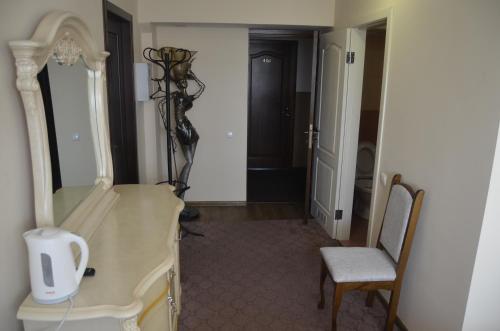 a hallway with a dresser and a chair in a room at Бізнес Центр & Готель в Центрі Міста in Umanʼ