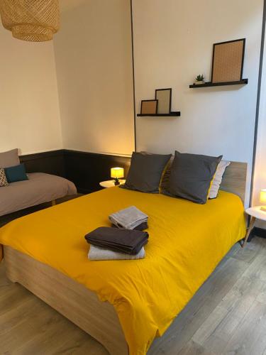 a bedroom with a yellow bed with towels on it at joli appartement quartier historique, 5 pers in Moulins