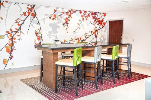 a kitchen with a bar with green chairs at Extended Stay America Suites Springfield in Springfield