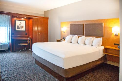 a hotel room with a large bed and a desk at MainStay Suites Springfield IL in Springfield