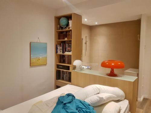 une chambre avec un lit et une étagère dans l'établissement PALAIS LUMIERE : la ''Chambre Blanche'', à La Ciotat