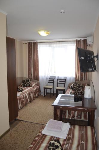 a hotel room with two beds and a desk at Бізнес Центр & Готель в Центрі Міста in Umanʼ