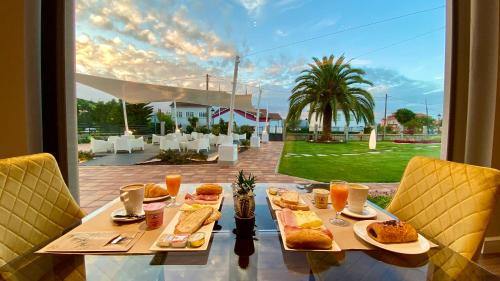 una mesa con comida y vistas a un patio en Harpazul, en Catoira