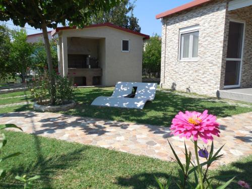 ogród z ławką i różowym kwiatem w obiekcie Costa Petra - Luxury Seaside Cottage with Garden - Vacation House for families in Greece w mieście Nea Mesangala