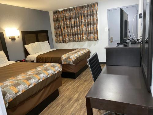 a hotel room with two beds and a flat screen tv at Hillside Motel Glen Mills in Glen Mills