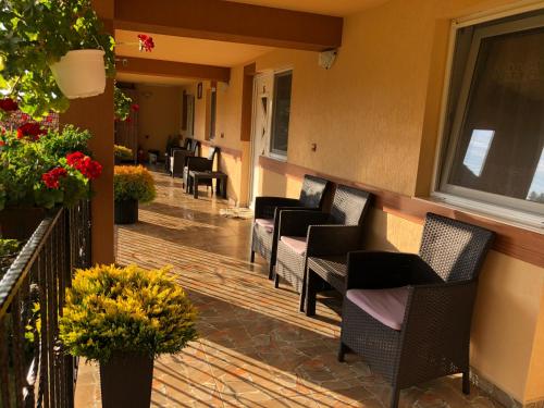 a balcony with chairs and flowers on a building at Casa Antonia in Chişcău