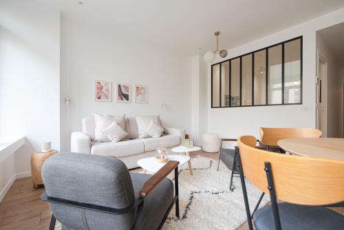 un salon avec un canapé, une table et des chaises dans l'établissement Luxury Residence - Paris South, à Montrouge