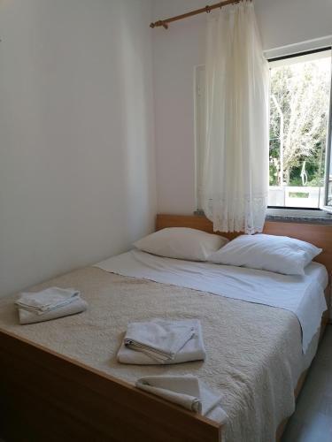 a bed with two towels on it with a window at Apartmani Rija 3 in Pag
