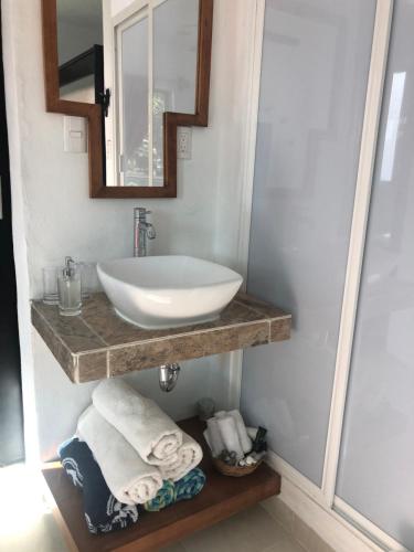 a bathroom with a sink and a mirror and towels at Casa Mango in Valladolid