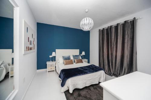 a bedroom with a bed and a blue wall at Luxury Suite Sea Front II in Playa Honda