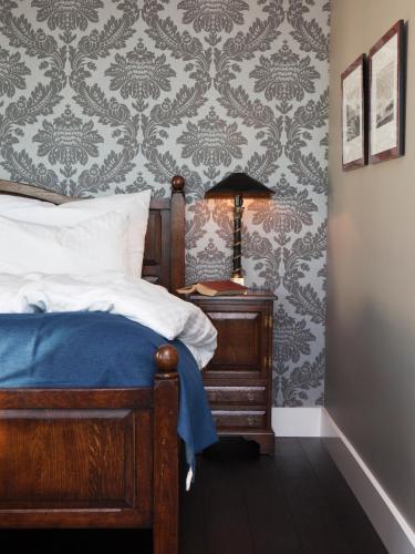 a bedroom with a bed and a table with a lamp at Støtvig Hotel in Moss