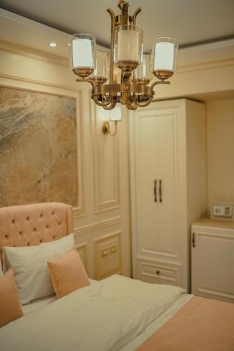 a bedroom with a bed and a chandelier at Miramar Boutique Hotel in Alexandria