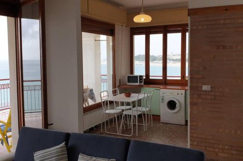 ein Wohnzimmer mit einem Sofa und einem Tisch mit Stühlen in der Unterkunft #southworking - Appartamento in villa sulla spiaggia a Soverato in Soverato Marina