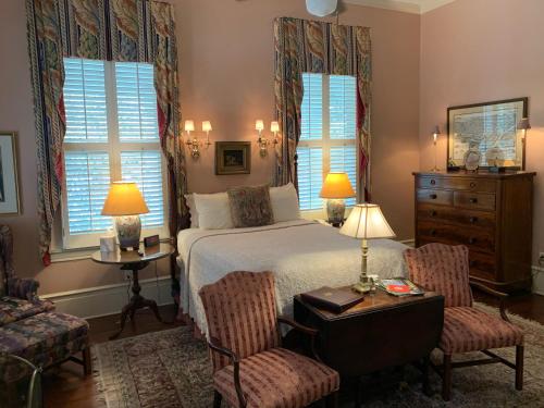 a bedroom with a bed and two chairs and a table at 1842 Inn in Macon