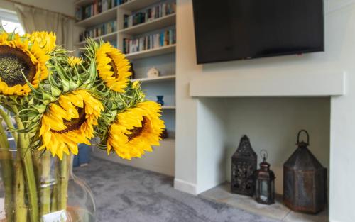 a vase filled with sunflowers sitting on a table at Number Five in Somerton