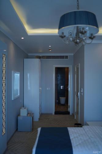 a blue bedroom with a bed and a chandelier at Miramar Boutique Hotel in Alexandria