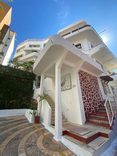 a large white building with a white roof at Hotel Amaca Puerto Vallarta - Adults Only in Puerto Vallarta