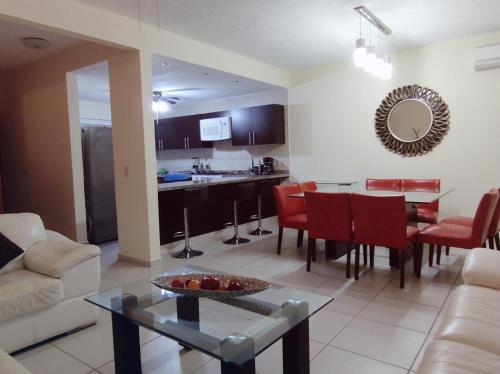 a living room and kitchen with a table and a couch at Villa Perfecta Zona Diamante in Acapulco