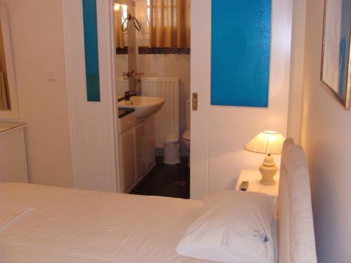 1 dormitorio con 1 cama, lavamanos y lámpara en Villa Christina Skiathos, en Vromolimnos