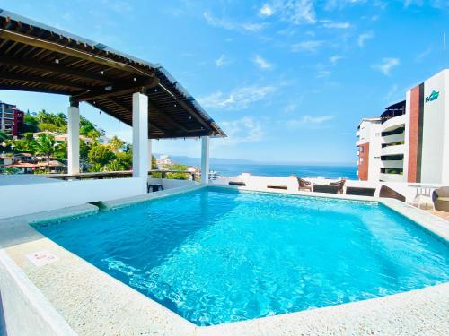 a swimming pool with a view of the ocean at Hotel Amaca Puerto Vallarta - Adults Only in Puerto Vallarta