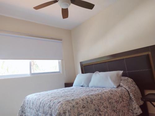 a bedroom with a bed with a ceiling fan at Villa Perfecta Zona Diamante in Acapulco