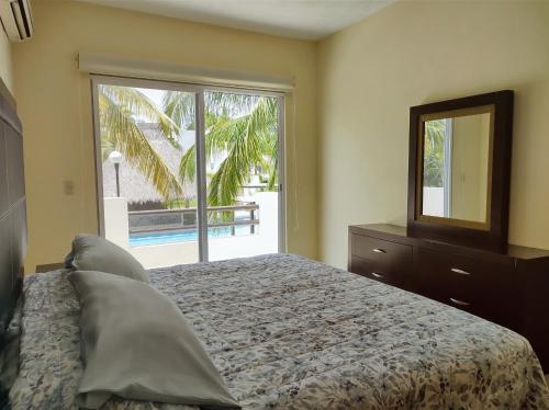 a bedroom with a bed and a mirror and a window at Villa Perfecta Zona Diamante in Acapulco