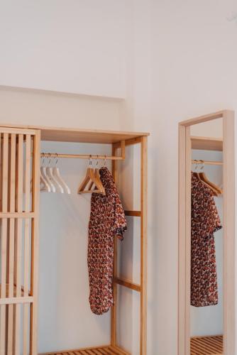 a closet with two dresses on hangers and a mirror at the SummerHouse Project in Perítheia