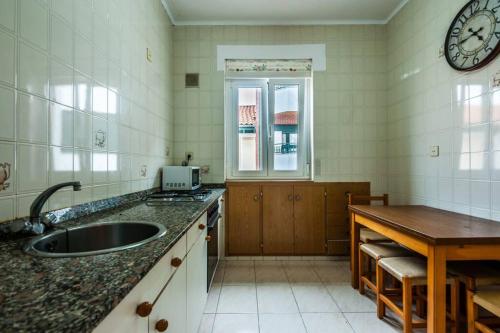 a kitchen with a sink and a clock on the wall at Santoña Paseo Marítimo 2ª linea playa, Llegada autónoma, Wifi in Santoña