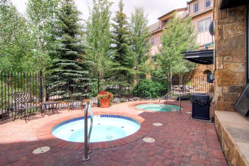 a hot tub in a brick patio with trees at Water House on Main Street in Breckenridge