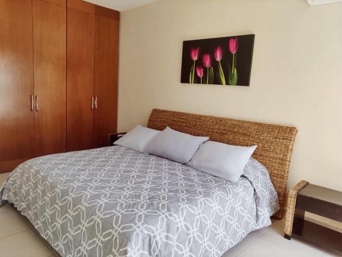 a bedroom with a bed with pink tulips on the wall at Casa Diamante en Zona Diamante in Acapulco