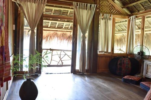 a living room with a large window with curtains at Lua Pu Luong in Pu Luong
