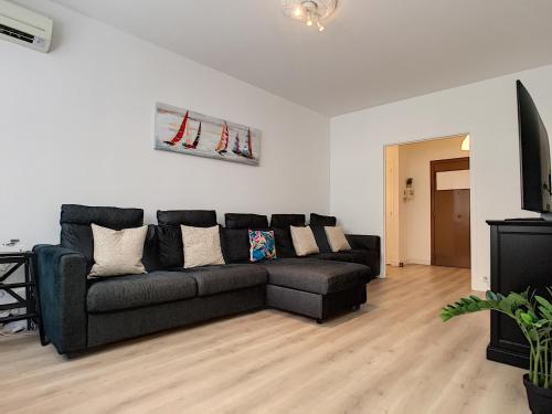 - un salon avec un canapé noir et des skis sur le mur dans l'établissement Nestor&Jeeves - BEETHOVEN - Central - Residential area, à Nice