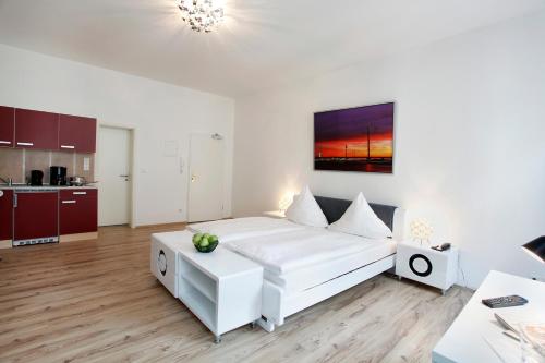 a living room with a white couch and a kitchen at Hotel Design Apart in Düsseldorf