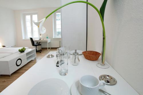 uma mesa branca com um vaso em cima em Hotel Design Apart em Dusseldorf