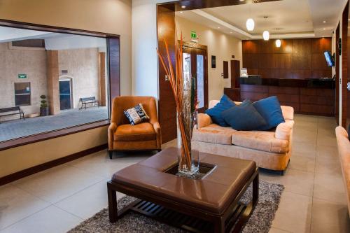 a living room with two couches and a table at Best Western Cumbres Inn Cd. Cuauhtemoc in Cuauhtémoc