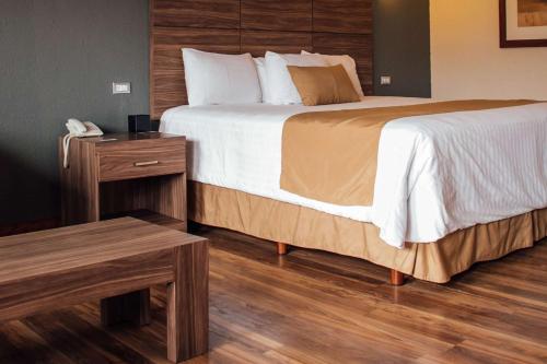 a hotel room with two beds and a table at Best Western Cumbres Inn Cd. Cuauhtemoc in Cuauhtémoc