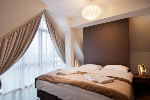sypialnia z dużym łóżkiem i dużym oknem w obiekcie Hotel Dobry Klimat w Szklarskiej Porębie