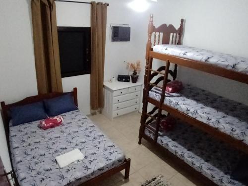 a bedroom with two bunk beds and a bed and a desk at Pousada Aconchego Bertioga in Bertioga